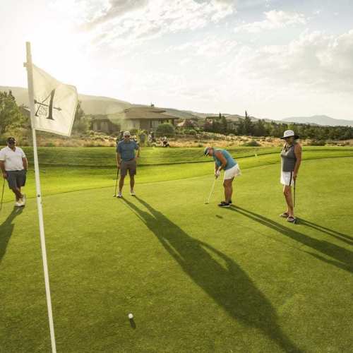 Group of golfers putting the ball into the hole at The Club at ArrowCreek