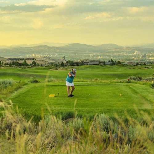 Female golfer takes a driving shot while golfing at ArrowCreek in Reno