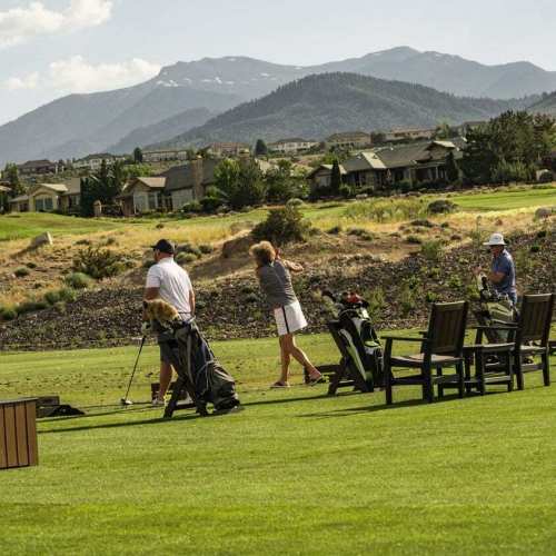 Golfers hit balls at the driving range at The Club at ArrowCreek
