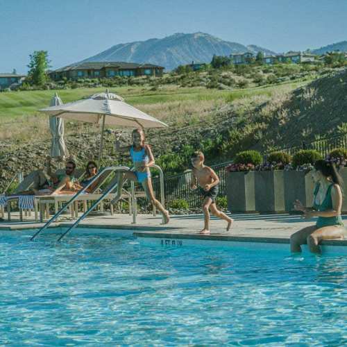 Two kids jump into the pool at The Club at ArrowCreek