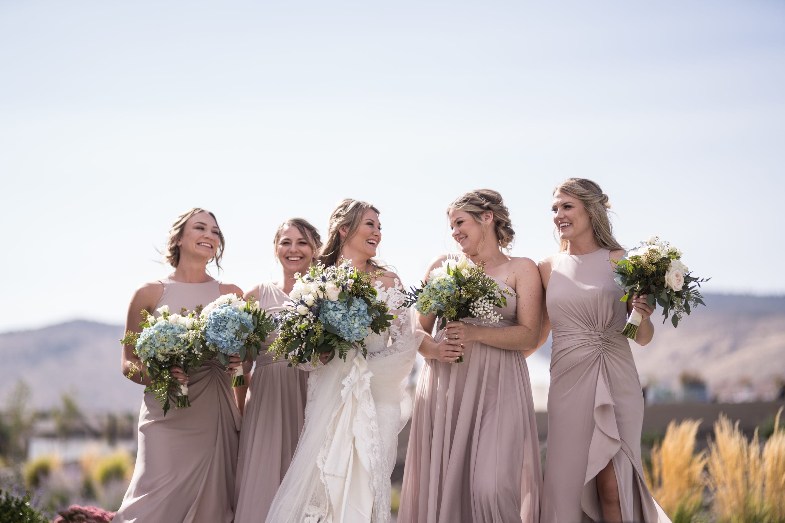 Bride and her bridesmaids laughing during her golf course wedding at The Club at ArrowCreek