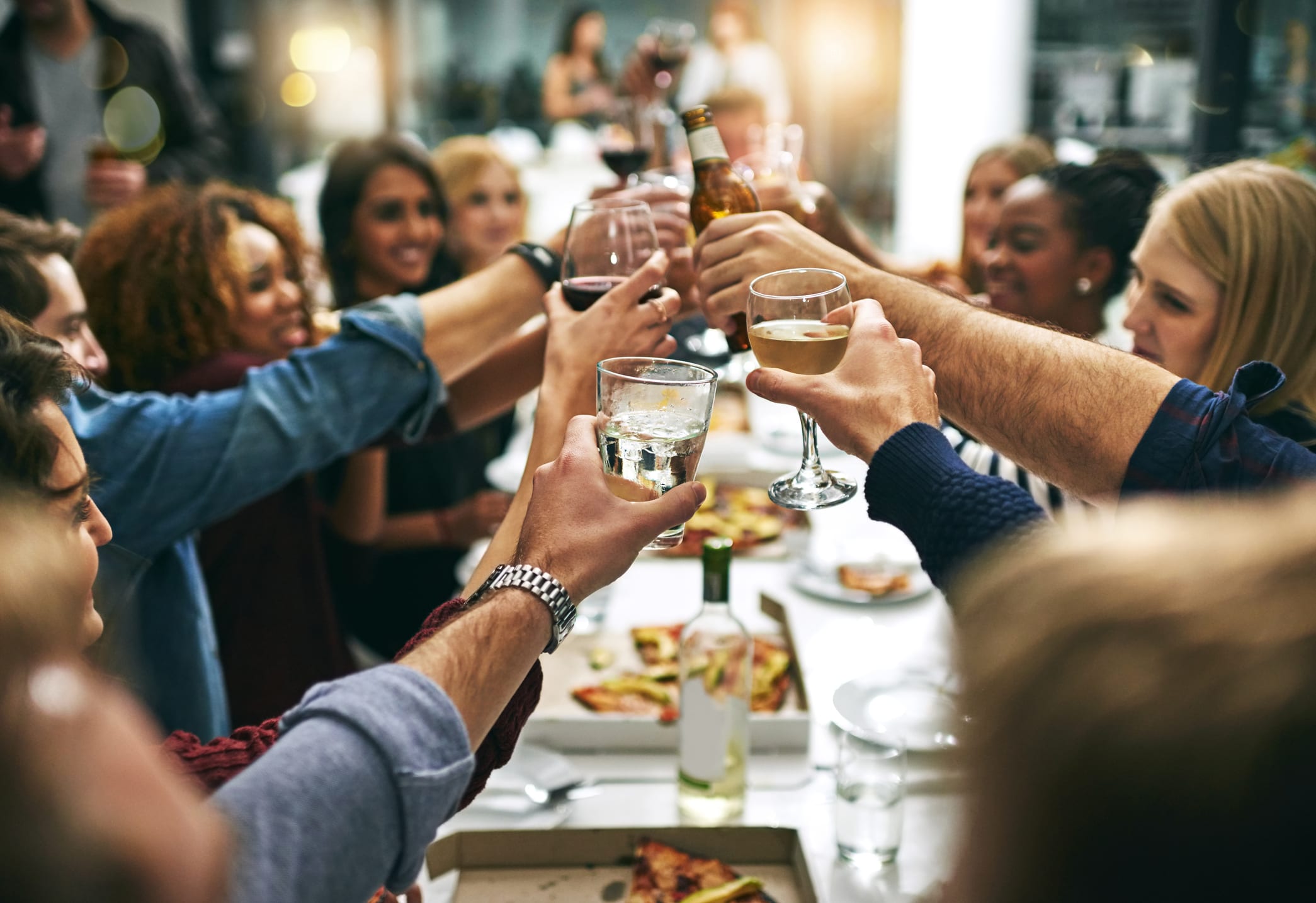 Cropped shot of a group of young friends toasting during a dinner party at a restaurant