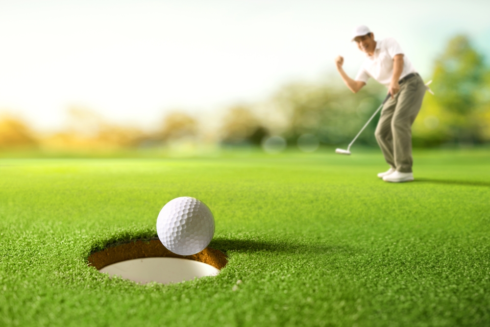 Golf ball near hole on lush green course